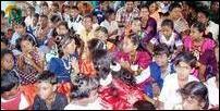 Children of resettled families attend the meeting in the new community hall