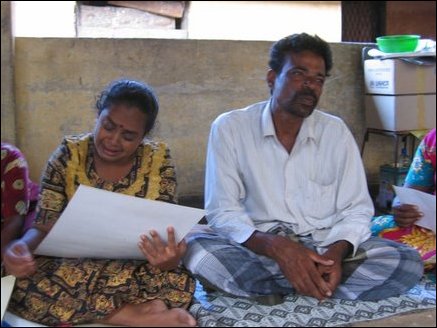 Kandasamy Yogathas wife Ithayaviji cries as she looks at her daughter's photograph at Methodist Central College welfare camp in Batticaloa.
