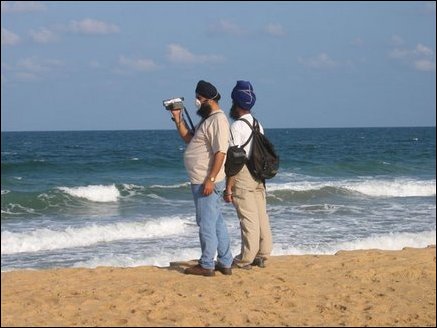 Two tourists from India capturing Navalady beach scenes.