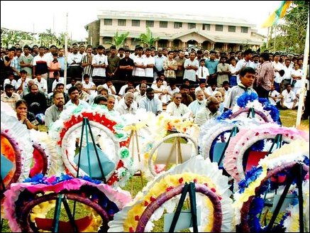 Trincomalee district parliamentarian Mr.Thurairatnasingham, lawyer, Mr.K.Sivapalan, and several leading citizens of the town are seen seated on the ground watching the funeral proceeding (Background Trincomalee Sri Koneswara Hindu College)