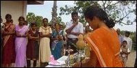 Parent lighting the traditional oil lamp.