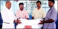 Rev.Fr Jeyakumar and Mr.Lawrence Christie handing over fishing nets to beneficiaries