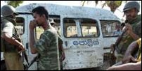 Sri Lankan Policemen stand guard at the site of a claymore mine ambush in Kattankudy, (AP Photo/Gemunu Amarasinghe)