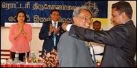Mr.Borham (L) being installed as new President of Trincomalee Rotary Club by outgoing Mr.Singarayer ( behind Rotary District Governor Mr.Senaweera, his wife greeting the occasion.