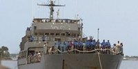 A soldier stands guard as a naval ship carrying about 800 people who had been stranded in northern Jaffna reaches a jetty in Trincomalee. (AP Photo)