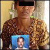Mrs Harishkrishnan, who lost her 2-year-old son in Sri Lanka Air Force bombardment and doesn't know the fate of her husband in captivity of the SLA, holding a photo of her husband [Photo: TamilNet]