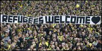 Borussia Dortmund supporters hold a banner showing their support for refugees (Photo: Courtesy AP)